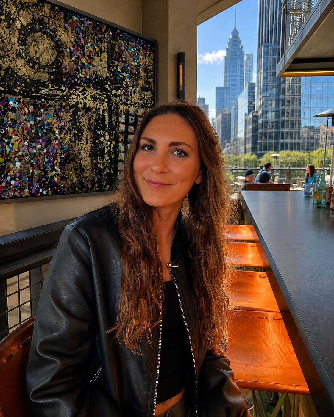 Kayce Bae, abstract expressionist from Katy, Texas, seated in front of one of her paintings