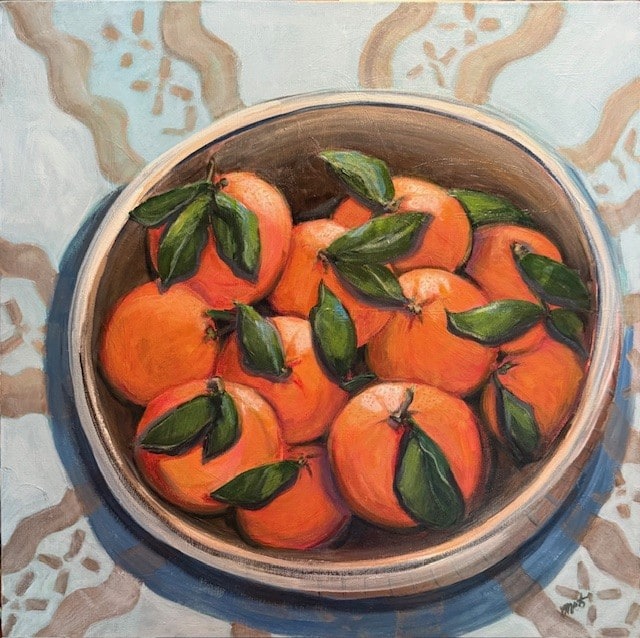 Acrylic painting of a bowl of oranges with green leaves on a patterned tablecloth by Melanie Toudouze