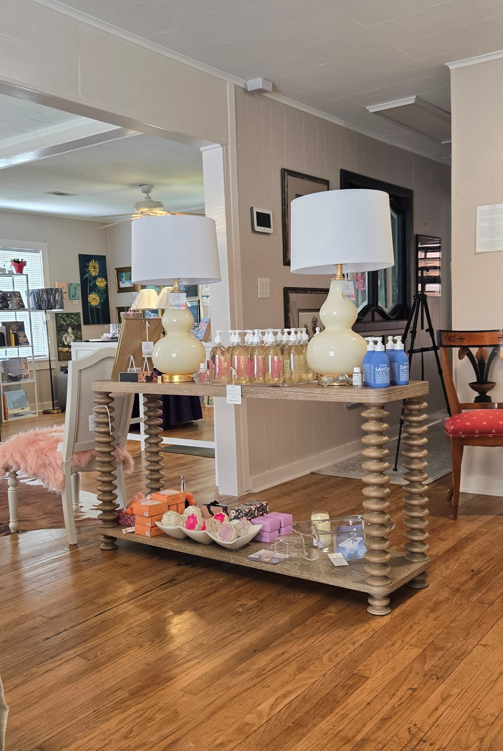 Inside Langley Art & Home, a spool-leg console with curated decor and gallery walls beyond