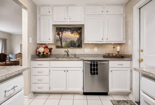 The finished kitchen with wallpaper, under-cabinet lighting, the Tuscany metal print, and silk florals.